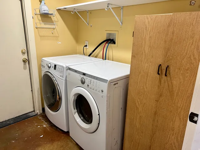 Shared Laundry area with wood-finish flooring, wall-mounted shelving, and a built-in storage cabinet