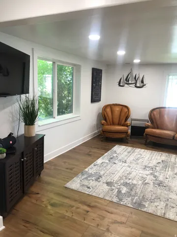 Recessed ceiling lighting illuminates the interior space, featuring wood-finish flooring and white baseboards