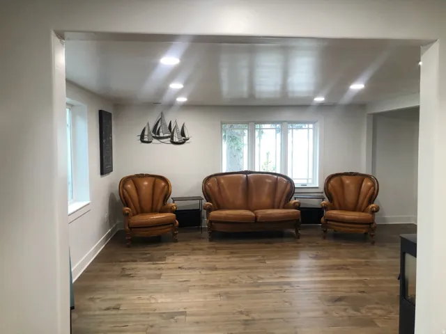 Recessed lighting illuminates wood-finish flooring