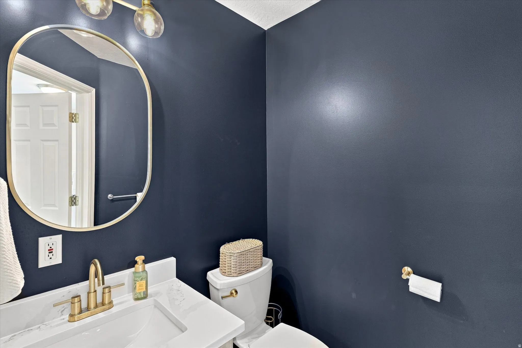 Vanity with integrated sink, brass-finish faucet, and stone-look countertop