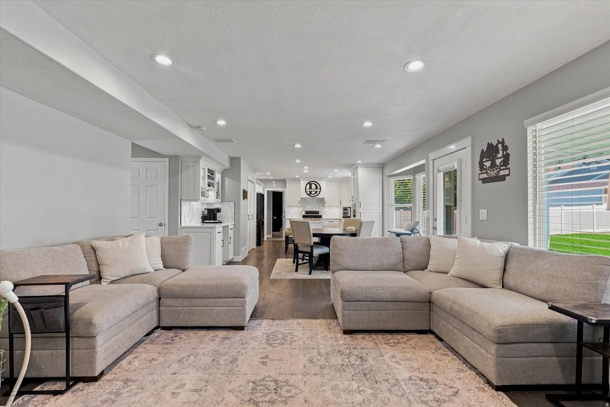 Recessed lighting, wood-finish flooring, white paneled doors, and ample natural light