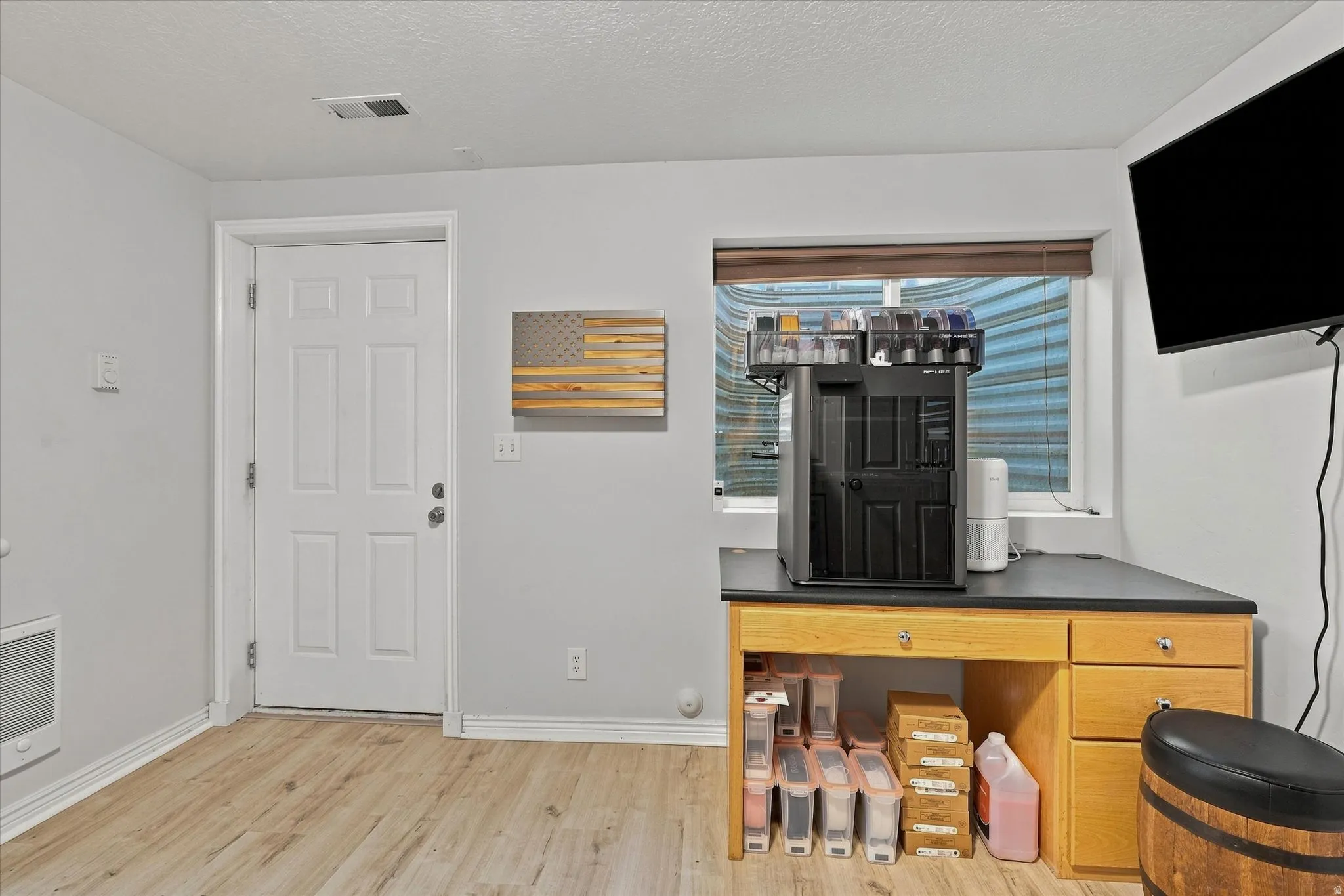 Wood-finish flooring, light gray wall paint, and a four-panel entry door