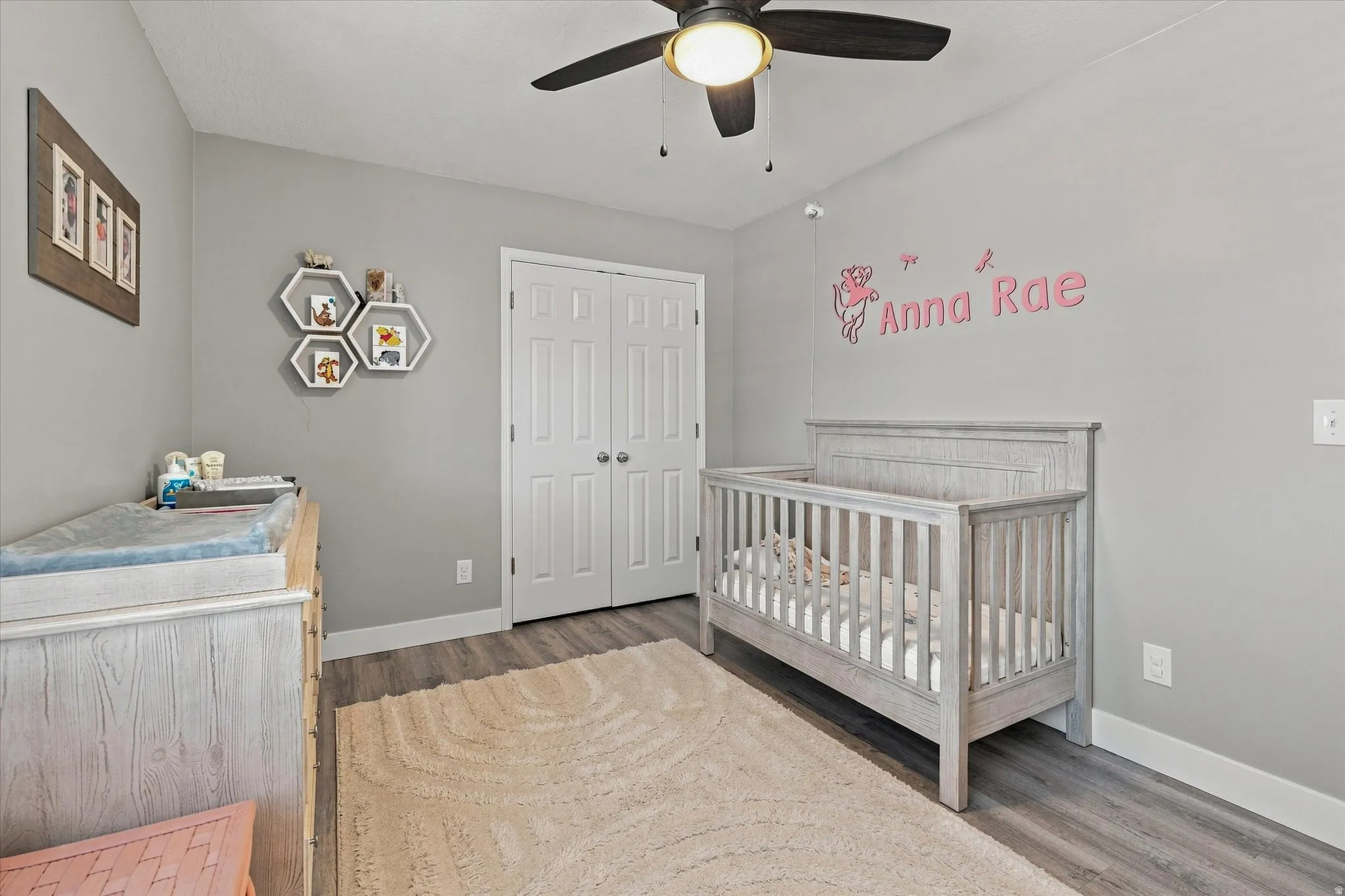 Neutral wall color, wood-finish flooring, ceiling fan, bi-fold closet doors, white baseboards