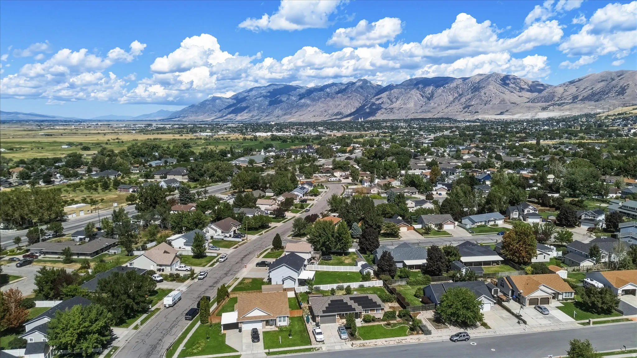 Expansive community with varied architectural styles, mature trees, and mountainous backdrop