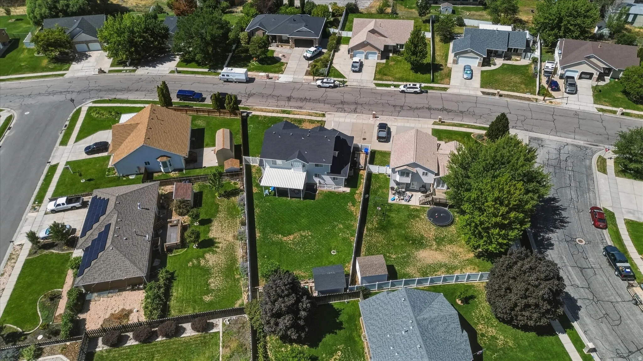 Expansive grassy yard with mature trees and perimeter fencing