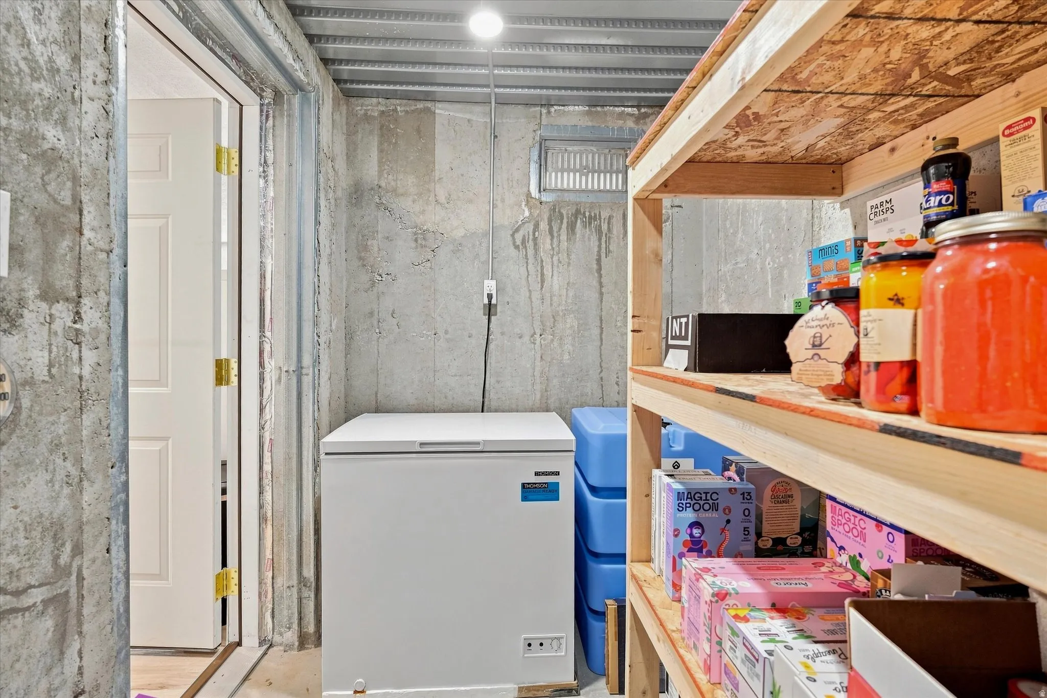 Concrete wall construction with built-in shelving and overhead utility lighting
