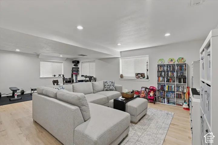 Recessed lighting, wood-finish flooring, multiple windows with blinds, and built-in shelving