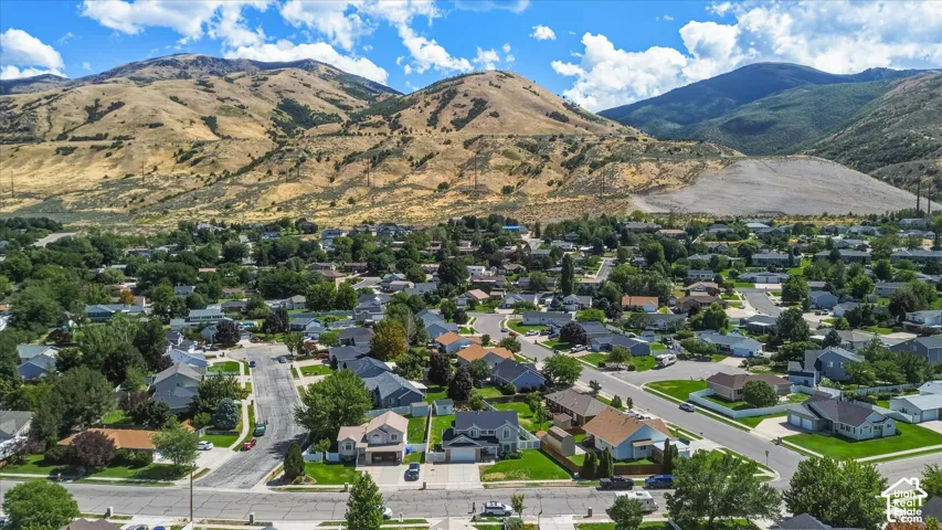 Residential neighborhood with established streets and mature trees, set against a backdrop of mountain terrain
