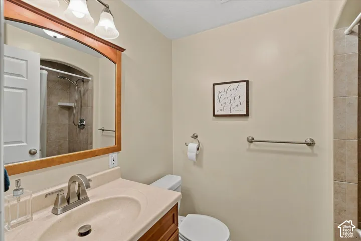 Vanity with integrated sink, wood-finish cabinetry, brushed nickel faucet, and framed mirror