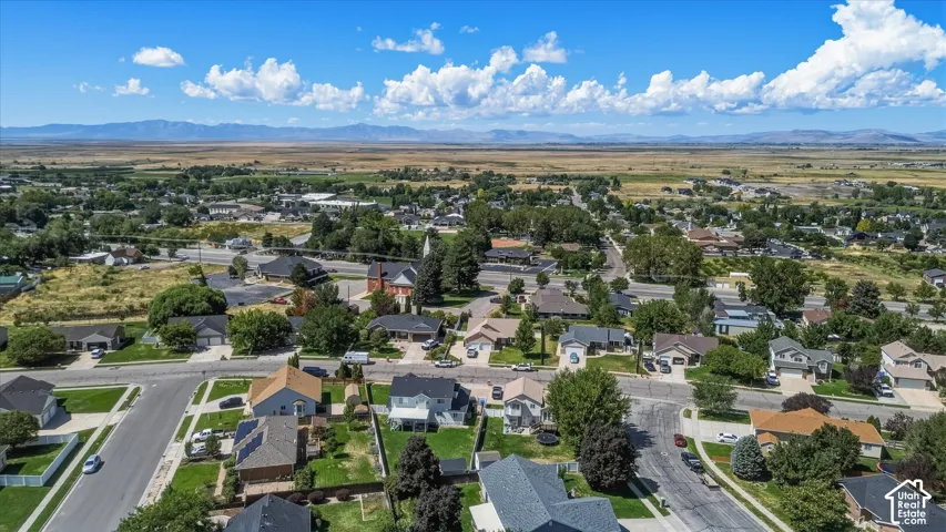 Residential neighborhood featuring paved streets, established landscaping, and distant mountain ranges