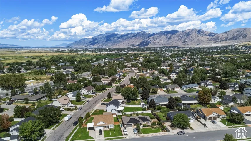 Expansive community with varied architectural styles, mature trees, and mountainous backdrop