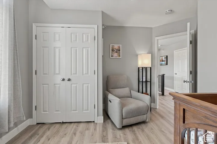 Wood-finish flooring, paneled bifold closet doors with satin nickel hardware, and light gray wall paint