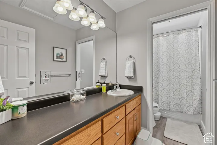 Wood-finish cabinetry with a built-in vanity sink, dark countertop, and large wall mirror