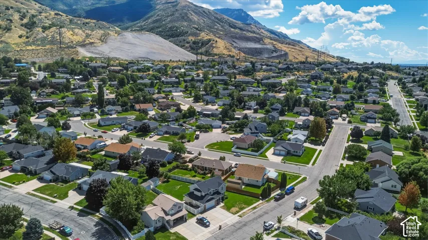 Residential neighborhood featuring paved streets, mature trees, and a mountain backdrop