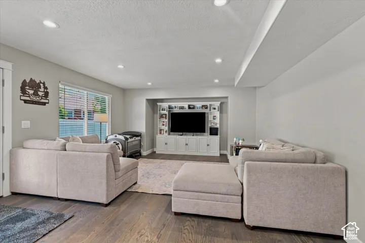 Recessed lighting, wood-finish flooring, and a built-in media center with shelving