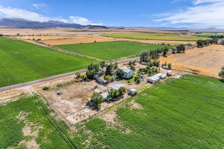 Expansive rural property featuring multiple outbuildings, a detached accessory dwelling unit, and direct access to a paved road