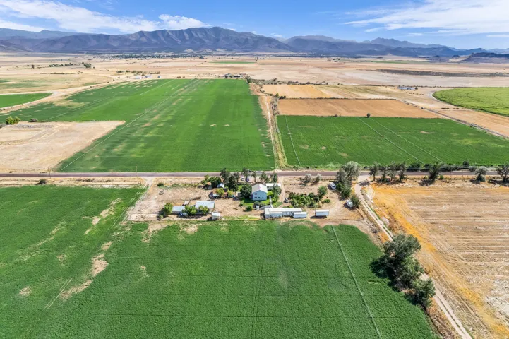 Expansive agricultural property featuring cultivated fields and a central residence