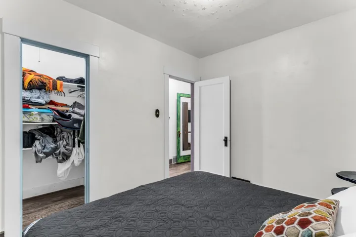 Built-in closet with shelving and wood-finish flooring