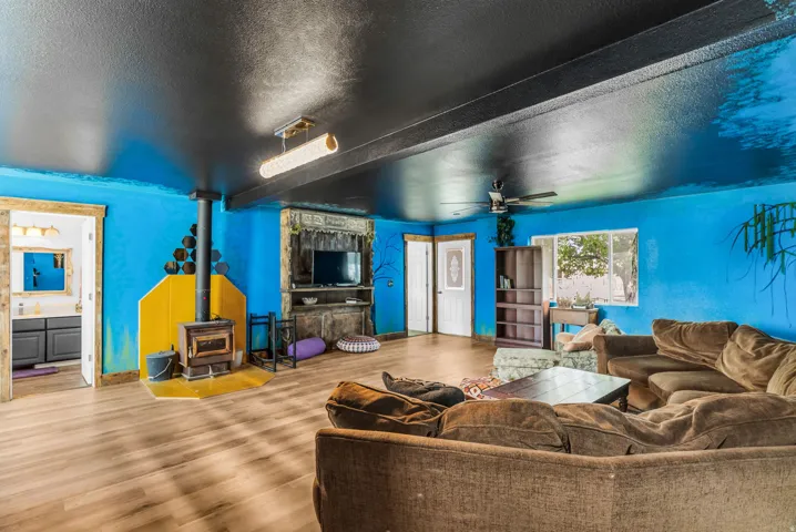 Wood-finish flooring throughout, featuring a built-in wood-burning stove with yellow surround