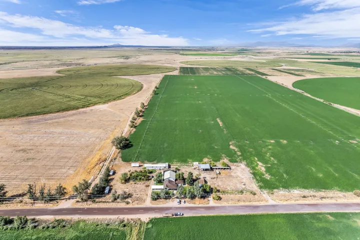 Expansive agricultural property featuring cultivated fields, circular crop patterns, and multiple structures