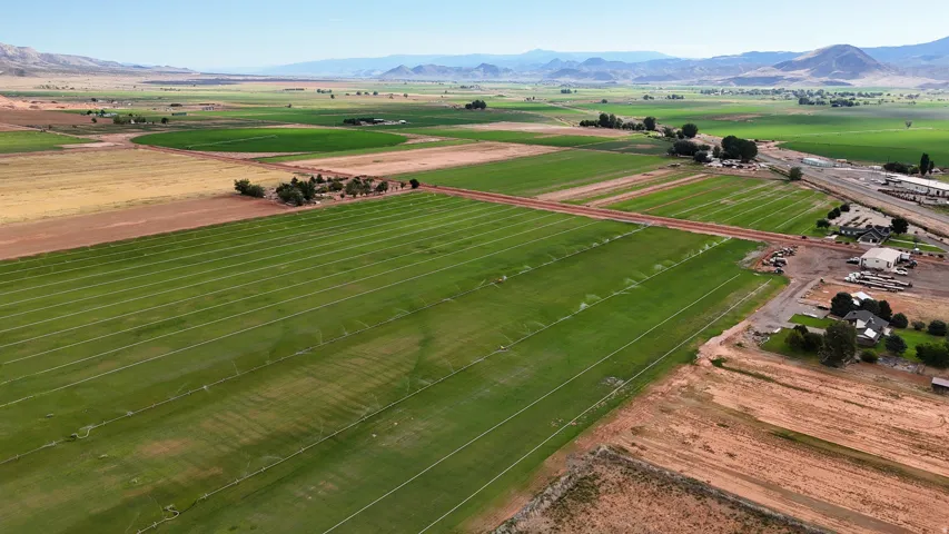 Expansive land featuring irrigated green fields, arid land sections, and distant mountains