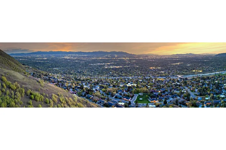 Expansive hillside setting with distant city lights and mountain ranges