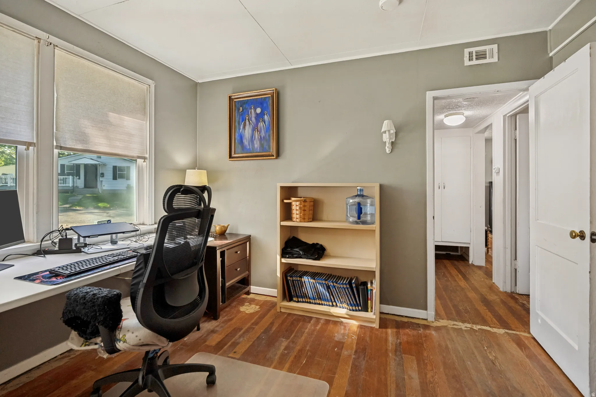 Hardwood flooring, painted walls, two large windows, white trim, and a white ceiling
