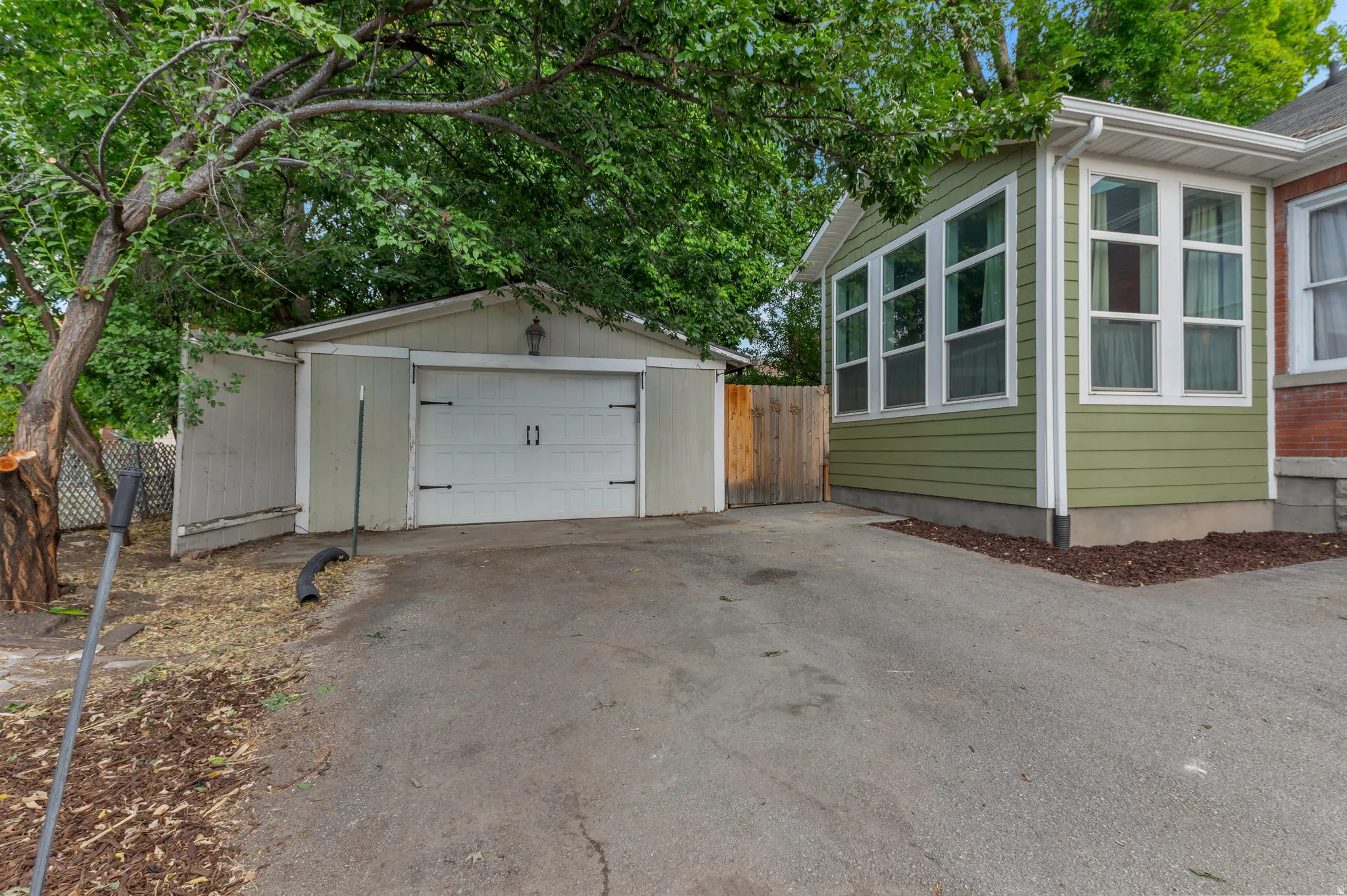 Detached garage with white overhead door and exterior lighting