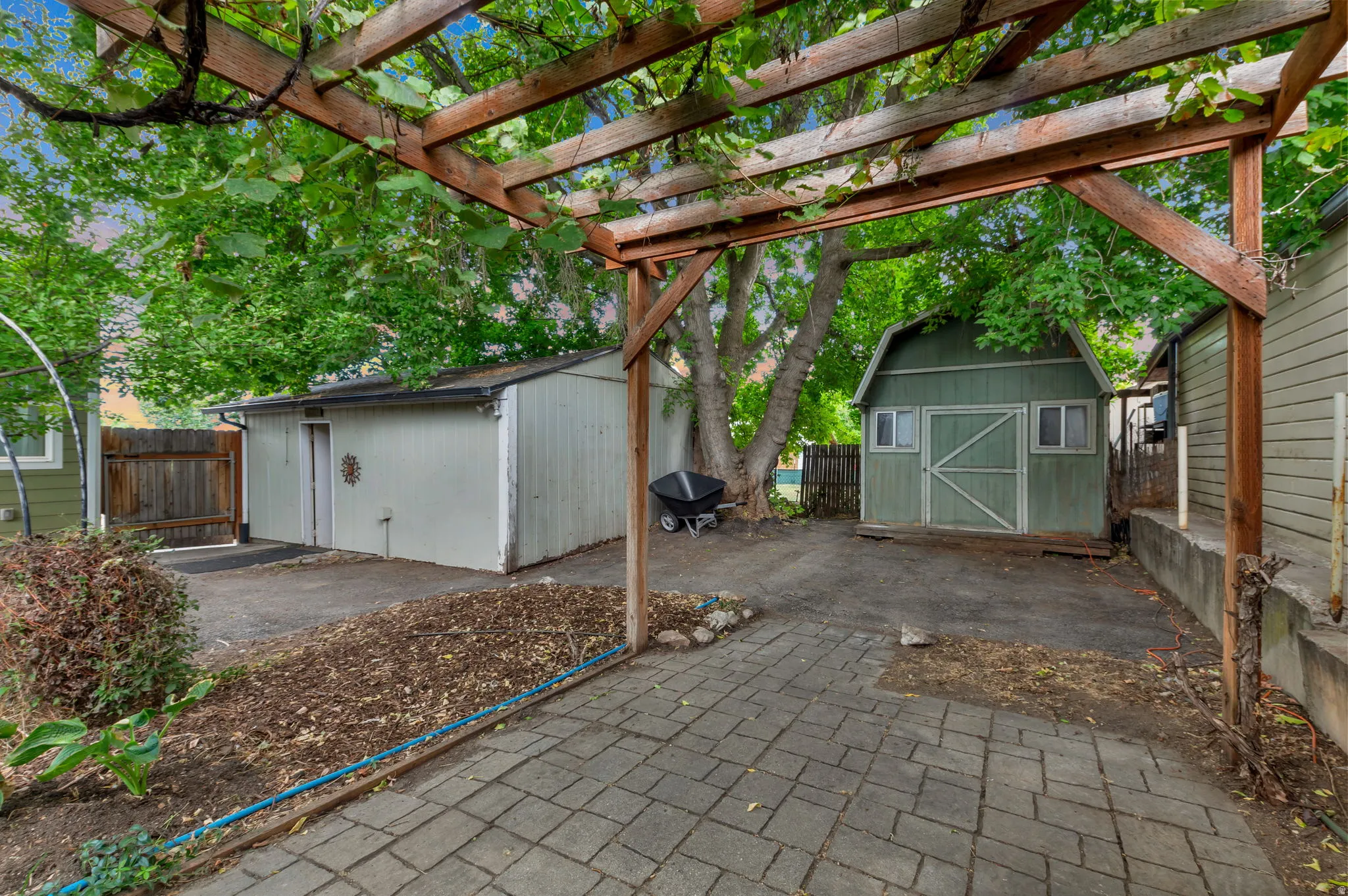 Paved patio area with an overhead pergola structure