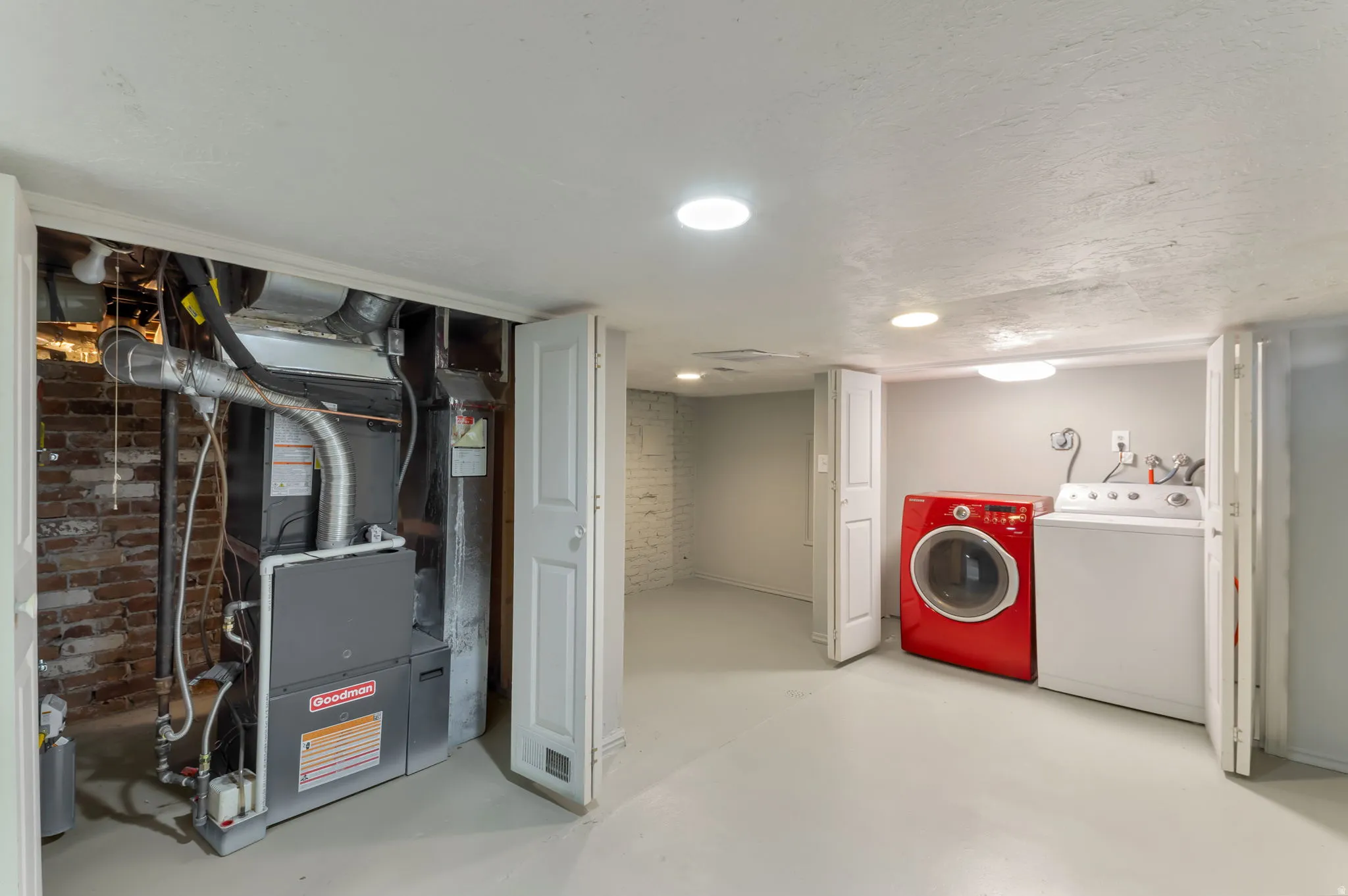 Laundry area with built-in utility hookups, recessed lighting, and a utility closet