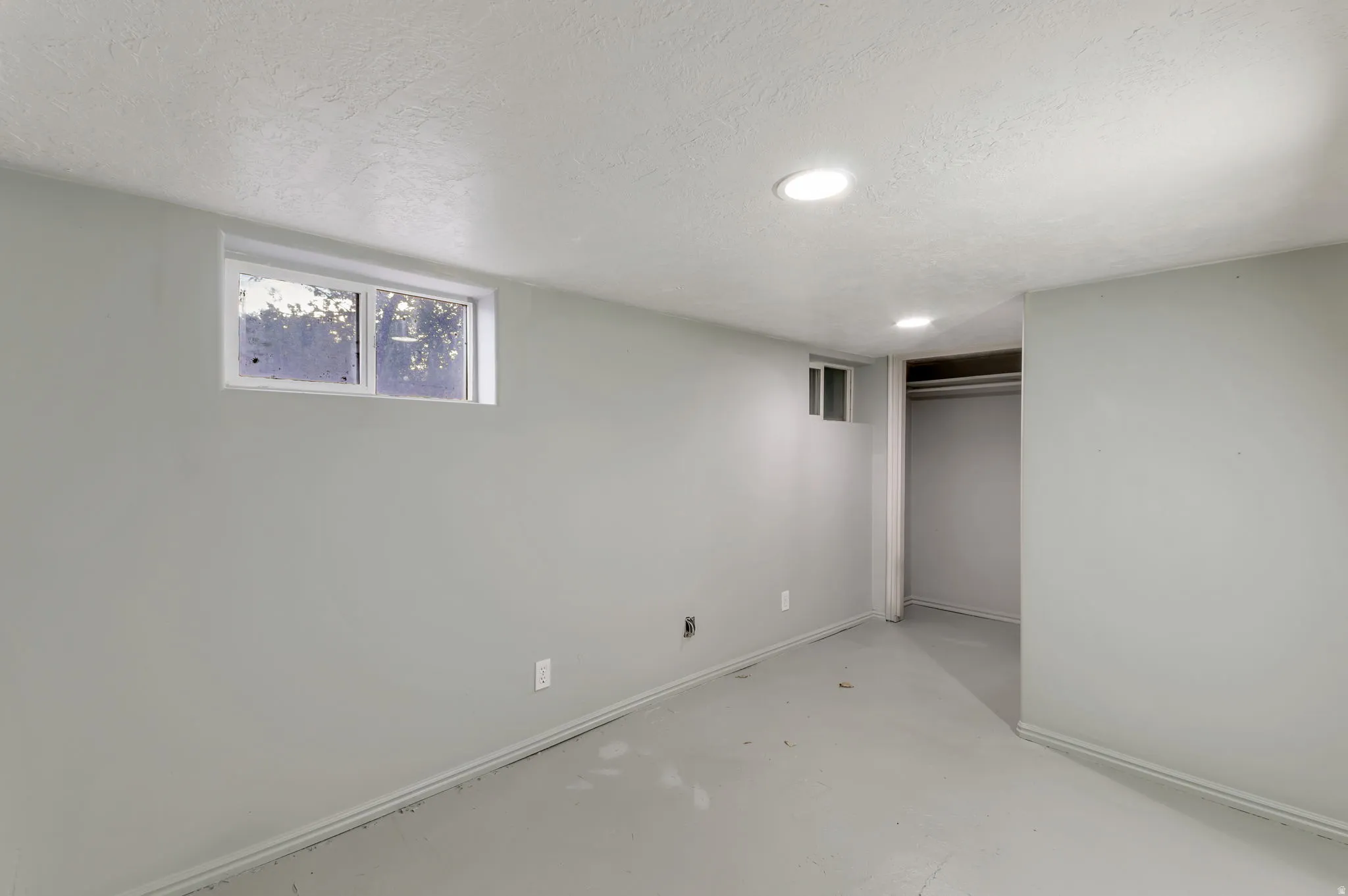 Recessed ceiling lighting, multiple windows, built-in closet with hanging rod