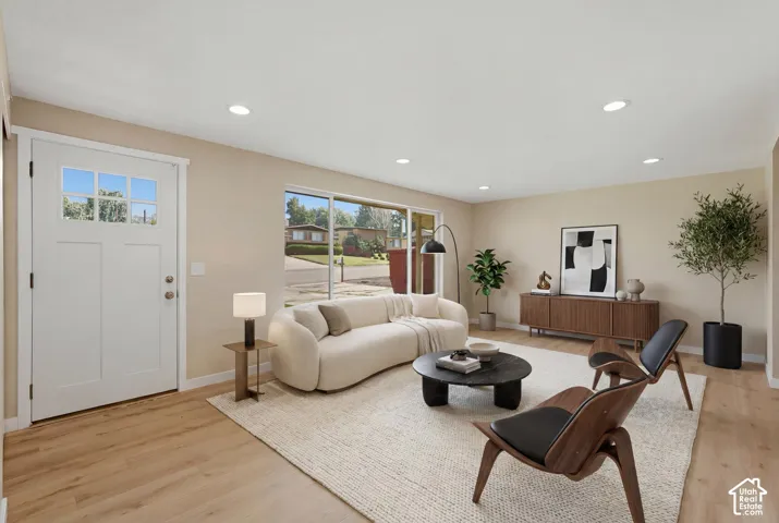 Recessed lighting, wood-finish flooring, white paneled door with glass inserts, large sliding glass window, and light-toned walls. Virtually Staged