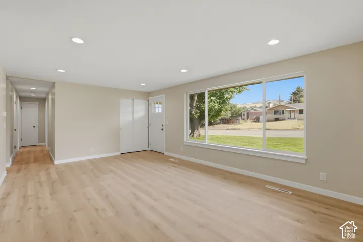 Recessed ceiling lighting, wood-finish flooring, wide window, paneled interior doors, and a front entry door with lites