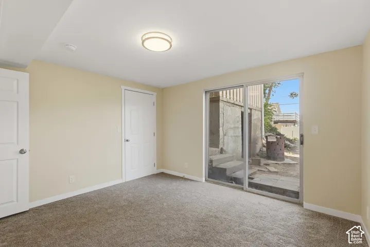 Soft beige wall tones, plush carpeting, white interior doors, and a sliding glass door providing outdoor access