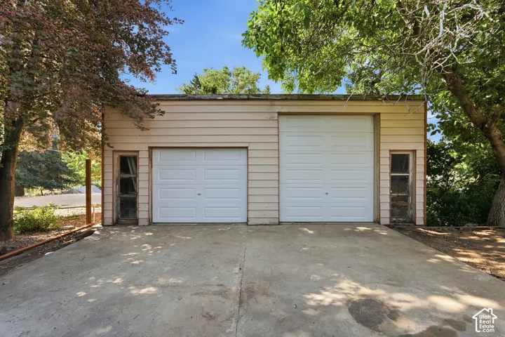 Two-car detached garage with panel doors and side windows, set on a concrete driveway