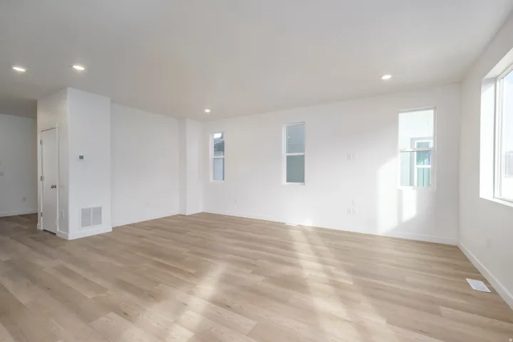 Bright interior featuring wood-finish flooring, recessed lighting, and multiple windows