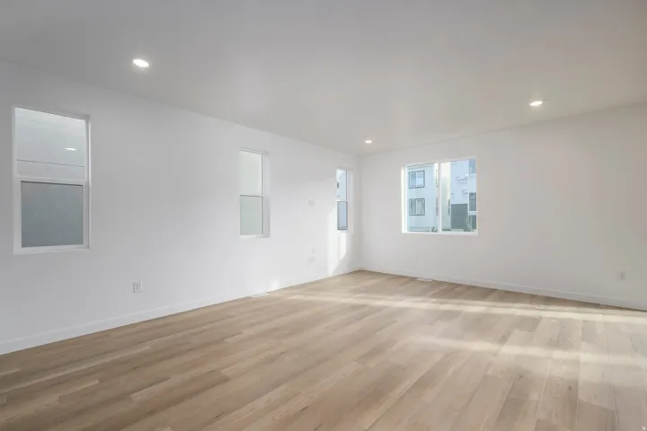 Recessed lighting, multiple windows, wood-finish flooring, white walls, and white trim