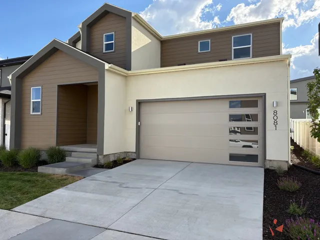 Contemporary exterior with a two-car garage, concrete driveway, stucco siding, and a covered entryway