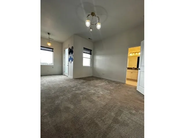 Large ensuite bedroom with blue accent wall, walk-in closet and balcony