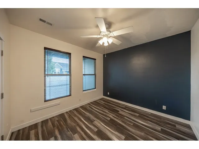 Main floor ensuite bedroom with accent wall and walk-in closet.