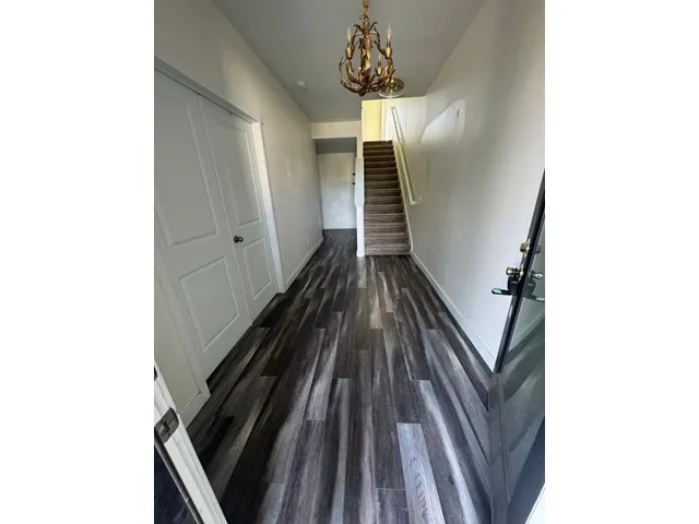 Entry leads to ensuite bedroom (French doors on left) stairway to 2nd floor, utility closet and garage entry.