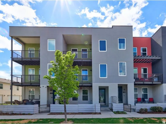 Modern townhouse with multi-level design, individual balconies, varied exterior siding, and a private entry