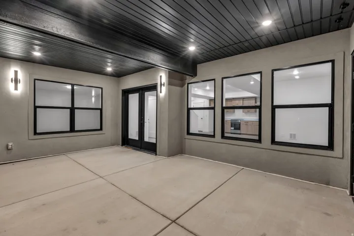 Covered patio featuring concrete flooring, recessed lighting, and wall-mounted sconces