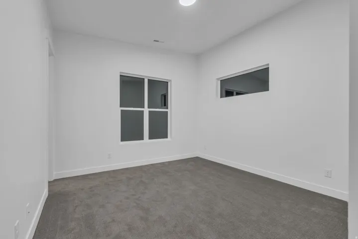 Neutral wall color, recessed lighting, and carpeted flooring