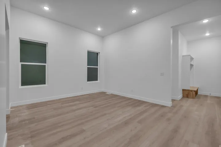 Recessed lighting, wood-finish flooring, two large windows, and a built-in storage bench