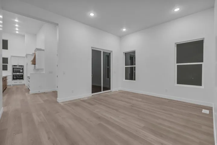 Open-concept living space featuring wood-finish flooring, recessed lighting, and white walls