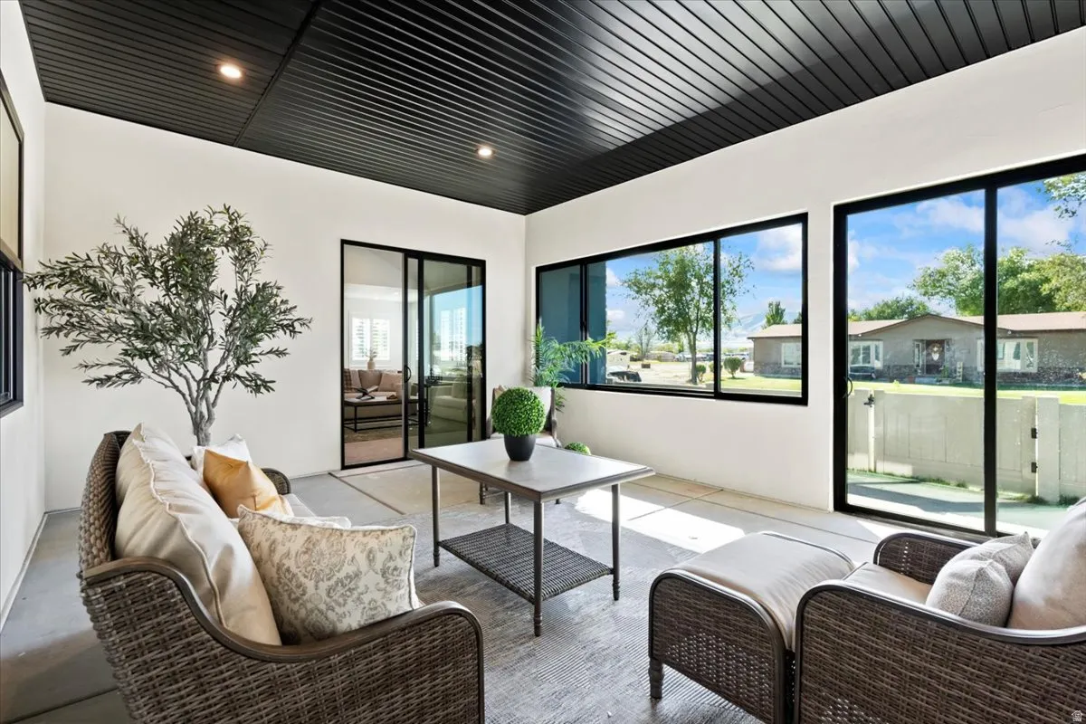 Enclosed patio with black paneled ceiling, recessed lighting, and large sliding glass doors
