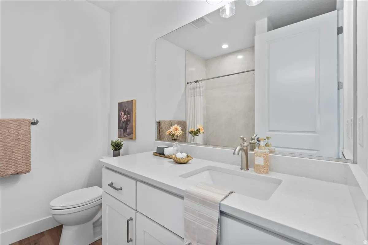 White vanity with an integrated sink, brushed nickel faucet, and a large wall-mounted mirror