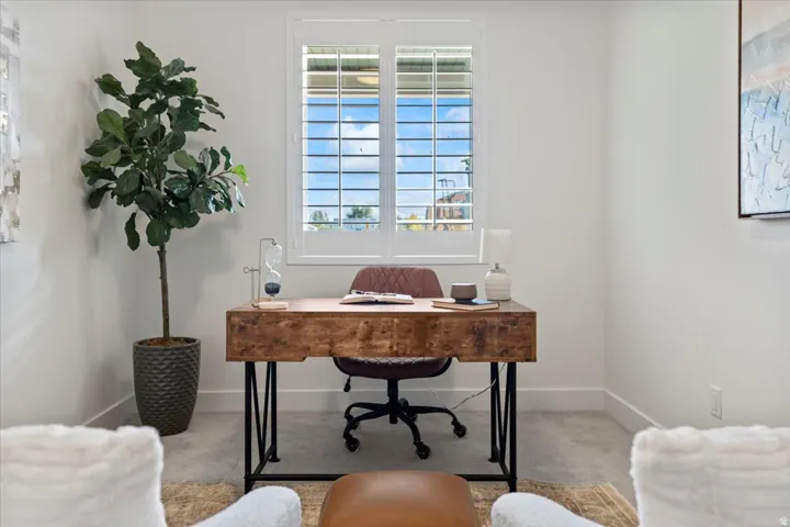 White walls, window with plantation shutters, and carpeted flooring