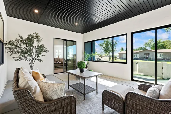 Enclosed patio with black paneled ceiling, recessed lighting, and large sliding glass doors